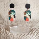 Studio Joy earrings with a woman amongst palm leaves